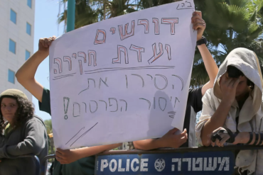Supporters of Duma suspects hold up sign reading: "We need an investigation committee - End the lack of transparency!" - Shabak testimonies will be closed to the public