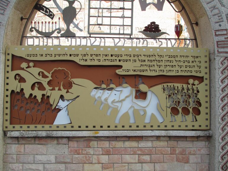 Decorations from an Akko Synagogue depict images from the Hanukah story