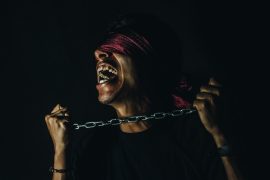 "Corporate Idolatry" by Helena Hawkins - blindfolded person trying to break free from chains